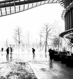 People walking on wet street in city