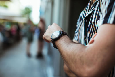 Close-up of man holding hand against blurred background