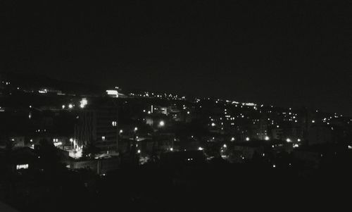 Illuminated cityscape against sky at night