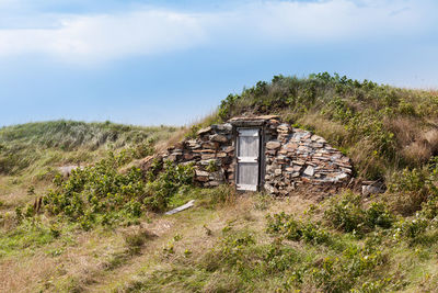 Built structure on field against sky