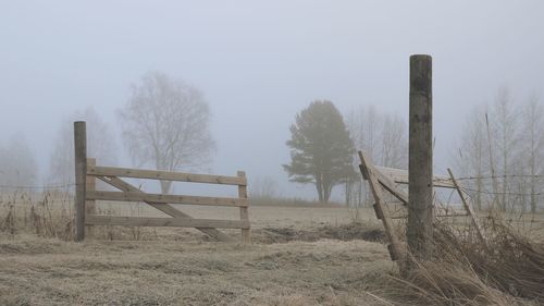 Wooden fence on field against sky