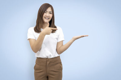 Portrait of smiling young woman against white background
