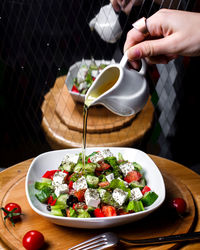 Cropped hand of woman preparing food on table