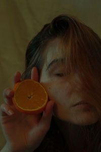 Close-up of teenage girl holding orange
