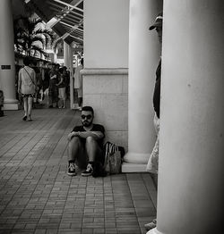 Rear view of man sitting in front of building