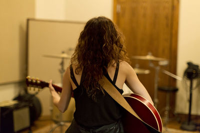 Young woman playing an electric guitar