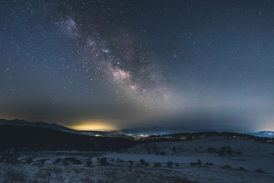 Scenic view of snowcapped mountains against sky at night