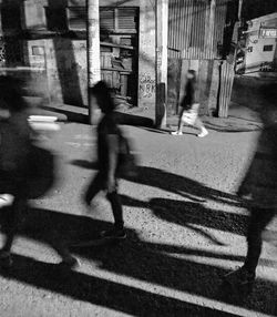 Shadow of man walking on street against buildings in city