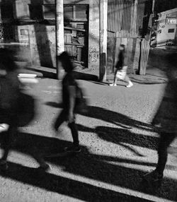 Shadow of man walking on street against buildings in city