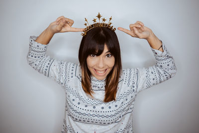 Portrait of young woman standing against wall