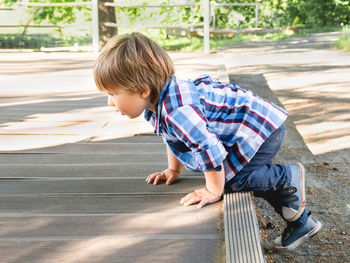 Curious toddler is climbing upstairs in recreation park. leisure activity for little children. 