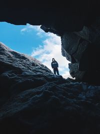 Low angle view of man on rock against sky