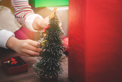 Cropped hand of person decorating christmas tree