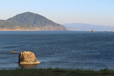 Scenic view of lake and mountains against clear sky