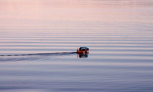 View of tractor on landscape against sky during sunset