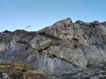 Low angle view of rocky mountains against clear sky