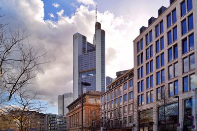 Low angle view of buildings against cloudy sky