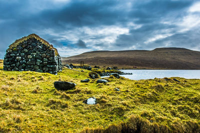 An old abandoned hamlet in the faroe islands. mountains and lake on background.