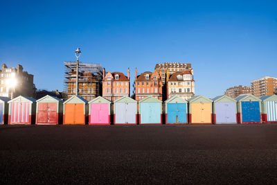 Colorful huts at beach against blue sky