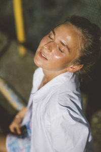 Portrait of a smiling young woman with eyes closed