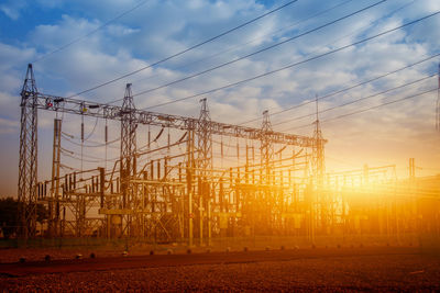 Electricity pylon against sky during sunset