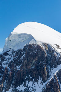 Scenic view of snowcapped mountains against clear blue sky