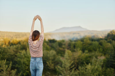 Rear view of woman standing on field