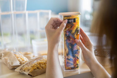 Midsection of man holding ice cream on table