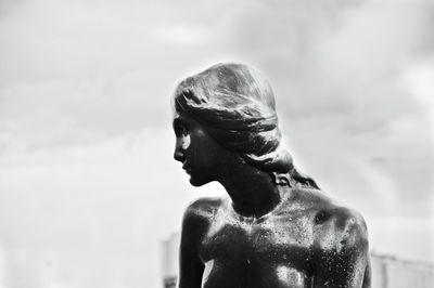 Close-up of old statue against sky