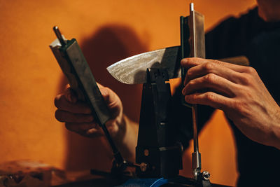 Cropped hands of manual worker repairing machinery in workshop
