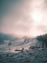 Scenic view of snow covered field against sky