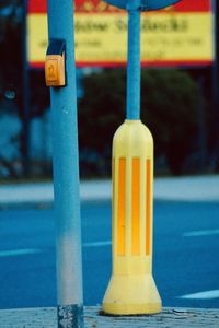 Close-up of yellow light on road by street