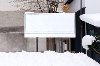 Snow covered house against building
