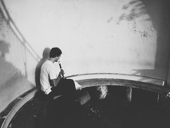 Rear view of boy sitting against wall