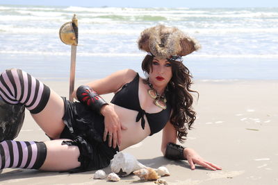  portrait of woman wearing costume while lying at beach