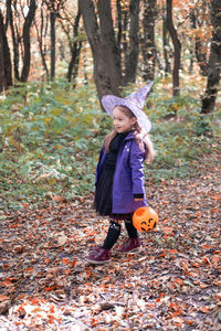 Halloween. cute little girl in witch costume with jack o lantern having fun outdoor