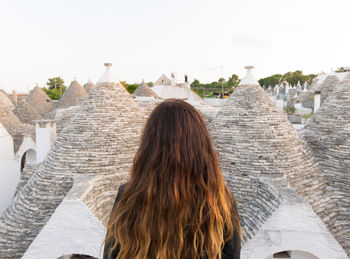 Rear view of woman standing in front of building