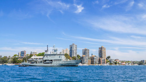 Sea by buildings against blue sky