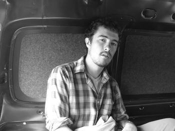 Portrait of young man sitting in car