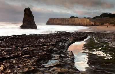Scenic view of rocks in sea against sky