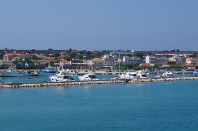 Town by sea against clear blue sky