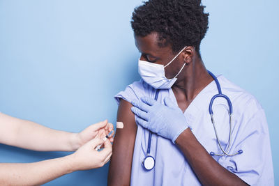 Midsection of doctor examining patient against white background