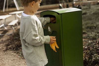 Boy throwing rubbish into bin