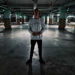 Full length portrait of young man standing in parking lot