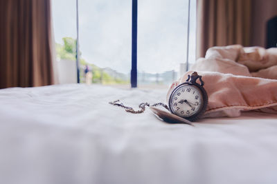 Close-up of clock on bed