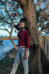 Full length of woman standing on tree trunk