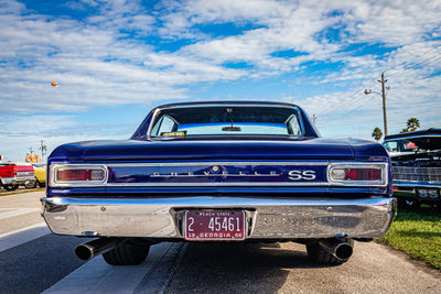 Vintage car on road against blue sky