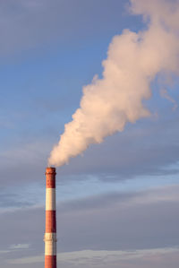 Smoke emitting from chimney against sky