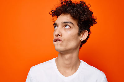 Portrait of young man against orange background