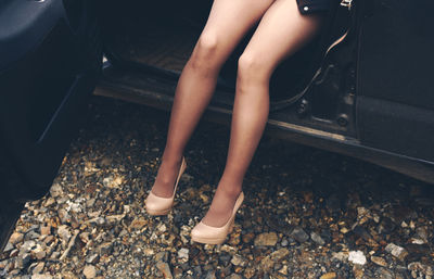 Low section of woman sitting in car